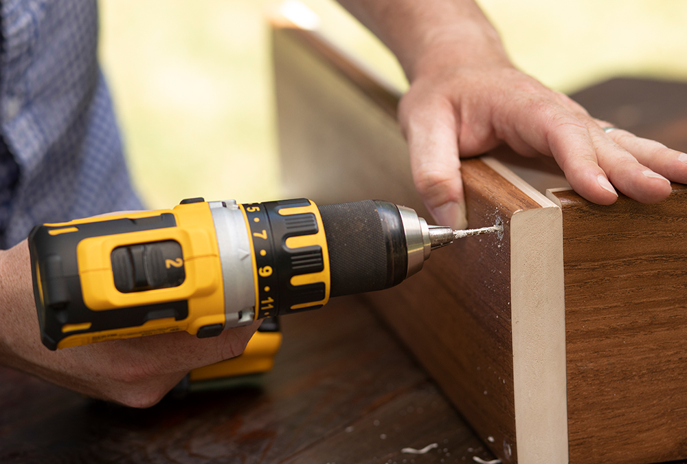 man using drill on wood