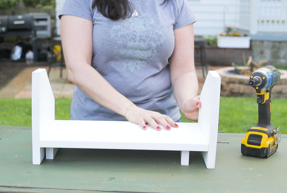 woman put together wood stand with drill