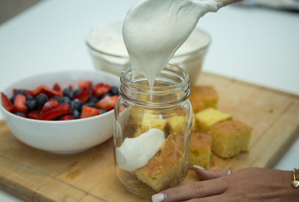 whipped cream going on top of cake in jar
