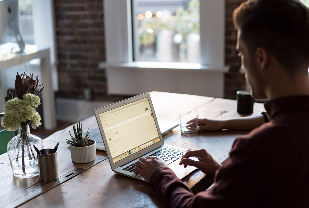 man at home desk with laptop