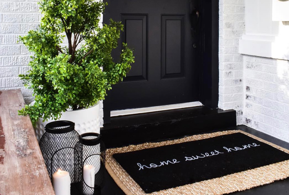 black front door layered welcome mat candles